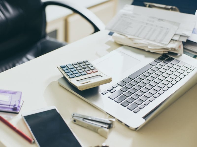 una calculadora sobre un escritorio junto a un ordenador portátil